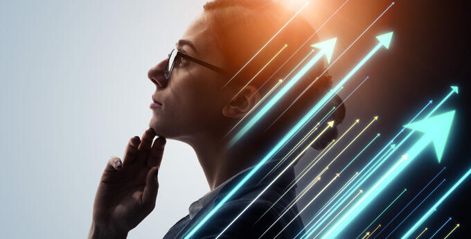 Woman looking up with glasses wearing a white shirt and a black blazer