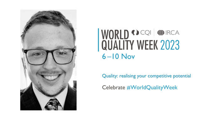 Mitchell Reed is pictured smiling in a suit and tie wearing glasses. The World Quality Week logo is to the right