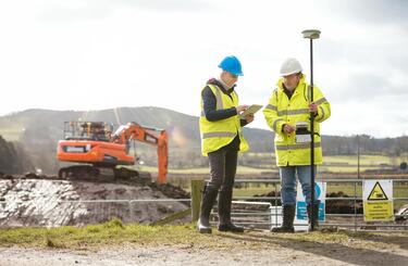 Construction workers examine a tablet