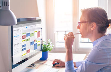 Women examines spreadsheet on computer screen