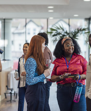CQI Networking Opportunities a group of mixed age professionals who are taking advantage of a networking opportunity at a business conference