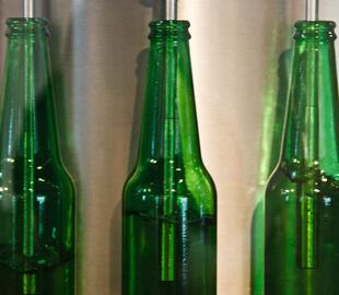 empty green beer bottle filled by machine