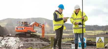 Construction workers examine a tablet