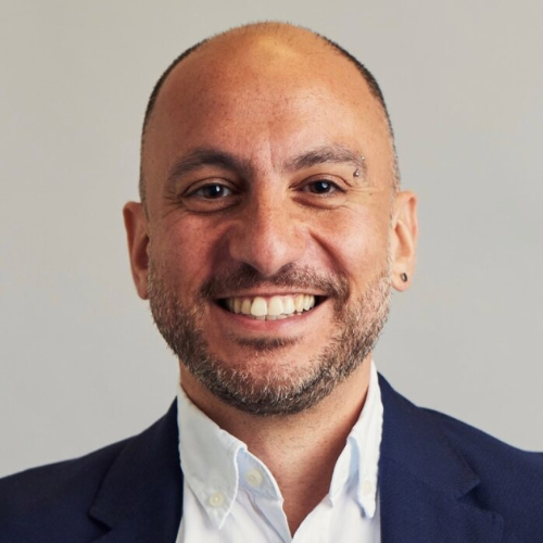 A portrait photo of Rashad Issa, dressed in a white shirt and navy blazer